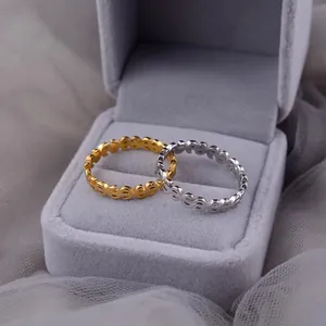 Detailed close-up of minimalist gold and silver dollar sign patterned rings in a velvet box