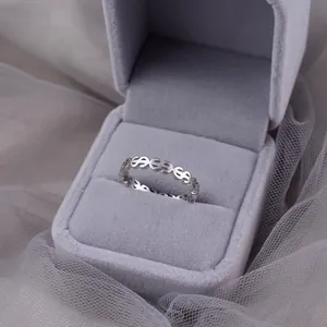 Macro detail of a minimalist silver ring with dollar sign hollow pattern