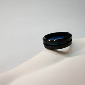 Nahaufnahme eines schwarzen mattierten Edelstahlrings mit markantem blauen Innennuten-Detail.