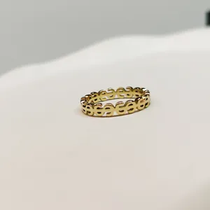 Close-up view of a minimalist gold finished ring featuring a unique series of dollar sign motifs