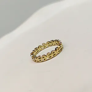Detailed macro shot of a gold-plated dollar sign pattern minimalist ring band.