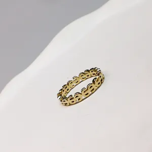 Close-up detail of the gold-plated cutout dollar sign pattern on a minimalist ring