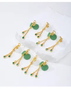 Vista detallada de colgantes de bolsa de la suerte dorados con borlas verdes e imitación jade.