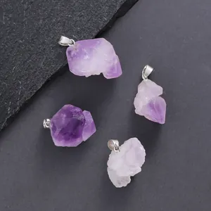 Set of four unique irregular raw amethyst stone pendants with silver bails on dark slate