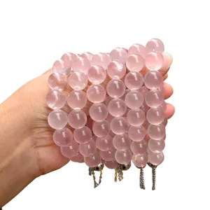 Bracelets de perles en quartz rose naturel haut de gamme pour femmes tenus en main