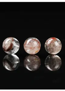 Primo piano di tre sfere di cristallo di quarzo fantasma naturale con inclusioni minerali.