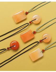Gros plan de pendentifs en jade naturel Huanglong, formes rectangulaire et circulaire sur jaune