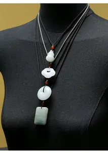 Gedetailleerd overzicht van traditionele Tianshan jade hangers op een zwarte mannequin