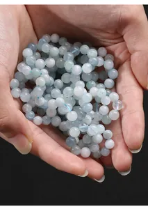 Close-up of high quality translucent natural aquamarine crystal beads being held in hands