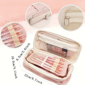 Detailed macro view of pink multifunctional pencil case showing pens, mesh pockets, and zippers
