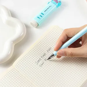 Close-up detail of a hand writing with a blue eternal pencil on a grid paper notebook