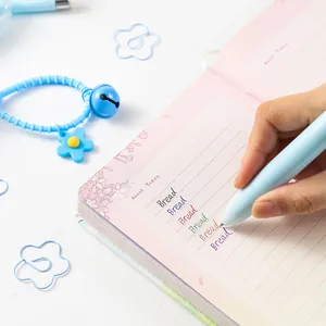 Macro view of light blue pen writing colorful notes in a pink stationery notebook