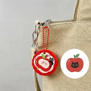 Primo piano di un mini taglierino carino a forma di gatto mela rossa su borsa beige