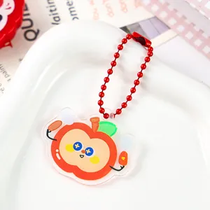 Close-up detail of a cute cartoon apple acrylic keychain with vibrant red bead chain