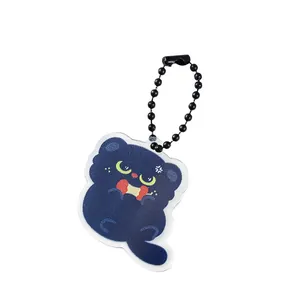 Kawaii dark blue acrylic cat keychain with grumpy expression holding a red bitten apple