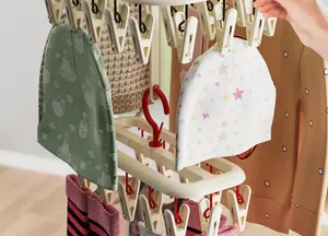 Close-up view of a multi-clip laundry drying rack holding colorful baby hats and socks