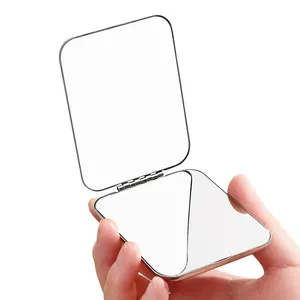 Portable mini stainless steel double-sided foldable pocket makeup mirror held in hand