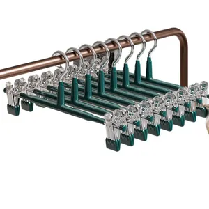 Set of dark green non-marking pants hangers with clips for skirts and trousers.