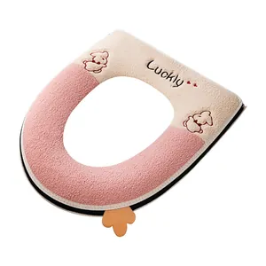 Plush pink and cream toilet seat cover with cute cartoon rabbit embroidery detail