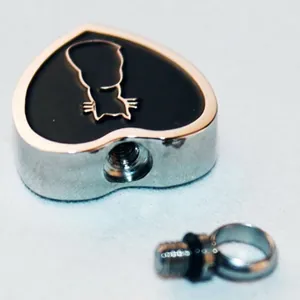 Collier urne cœur pour cendres d'animaux avec silhouette de chat dorée sur émail noir.