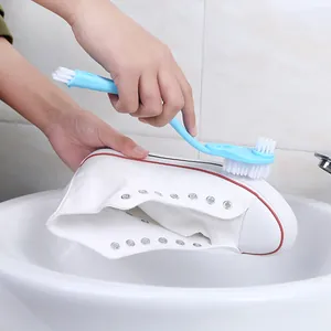 Blue long-handled double-headed shoe cleaning brush for scrubbing white canvas shoes