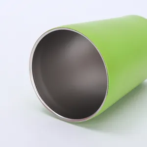 Nahaufnahme des glatten Randes und des Edelstahlinnenraums eines grünen Thermobechers.