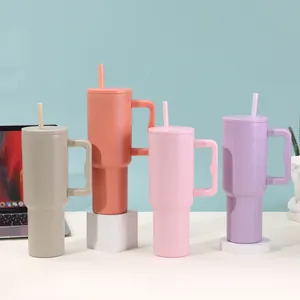 Four colorful 40oz vacuum insulated tumblers with handles and straws in a lifestyle setting.
