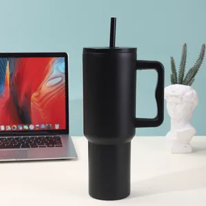 Matte black 40oz stainless steel vacuum insulated tumbler with handle and straw on a desk