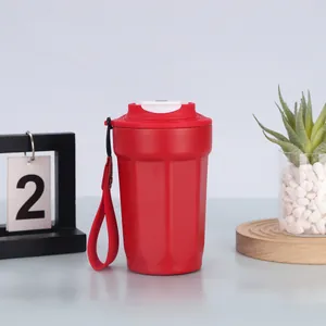 Moderna tazza da caffè ottagonale in acciaio inox 316 rossa con cinturino su una scrivania minimalista