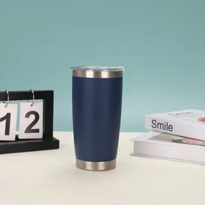 20oz isolierter Edelstahlbecher in Marineblau auf einem Schreibtisch mit Dekoration
