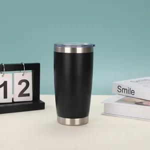 Moderner schwarzer 20oz vakuumisolierter Edelstahlbecher auf einem Tisch mit Dekorationen