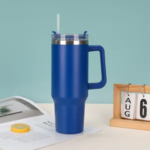 Blue 40oz vacuum insulated tumbler with handle and straw in a modern lifestyle setting