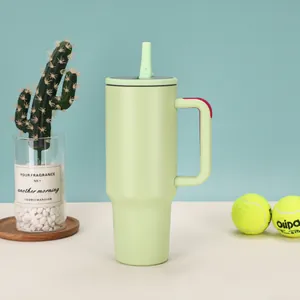 40oz light green insulated stainless steel tumbler with handle and straw in lifestyle setting