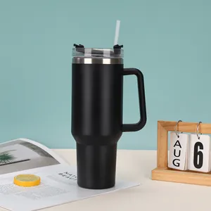 Large 40oz black vacuum insulated tumbler with convenient handle and straw on table