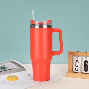 Vibrant red 40oz insulated tumbler with handle and straw in a lifestyle setting.