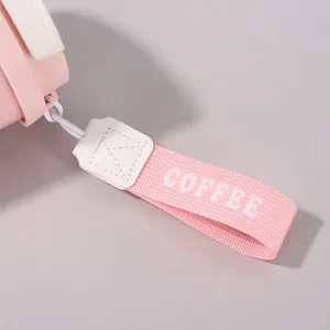 Detailansicht einer rosa gewebten Trageschlaufe mit COFFEE-Text an einem Thermobecher