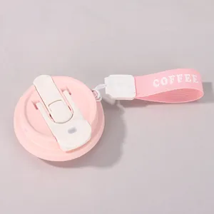 Detailansicht des rosa Kaffeetassendeckels mit praktischem Band und COFFEE-Schriftzug.
