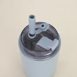 Nahaufnahme des transparenten Deckels und des grauen Silikonstrohhalms auf einem hellblauen Becher