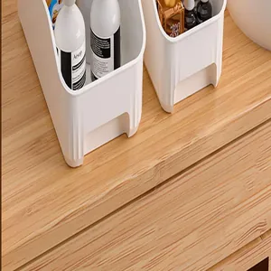Macro view of white plastic storage bins used for home organization on a wood surface