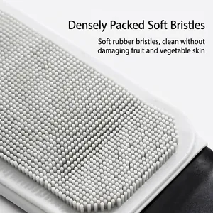 Flexible gray silicone fruit and vegetable cleaning brush with dense soft bristles