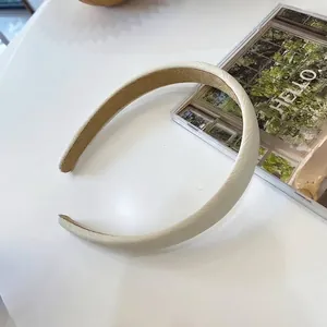 Dettaglio macro della fascia in tessuto crema con elegante motivo a trama di spiga di grano