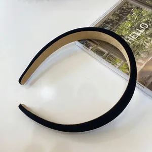 Dettaglio ravvicinato di un cerchietto in tessuto nero minimalista con fodera interna
