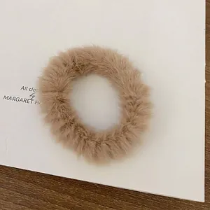 Soft faux fur hair scrunchie in milk tea color for autumn and winter styles.