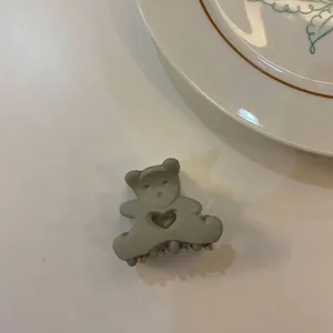 Gros plan d'une pince à cheveux mate grise en forme d'ours mignon avec cœur