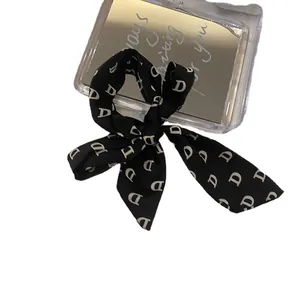 Chouchou ruban noir élégant avec motif de lettres pour une coiffure sophistiquée