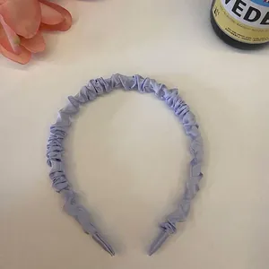Detailansicht eines hellblauen gefalteten 1cm Scrunchie Stirnbands auf weißem Untergrund