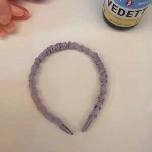 Nahaufnahme des lilafarbenen 1 cm gefalteten Scrunchie-Haarbands mit Satin