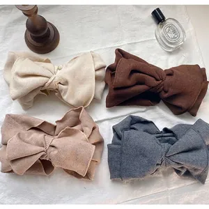 Set of four earth-toned ribbed cotton wide hairbands with oversized bow design