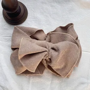 Detailed macro view of vintage ribbed cotton oversized bow headband in taupe color