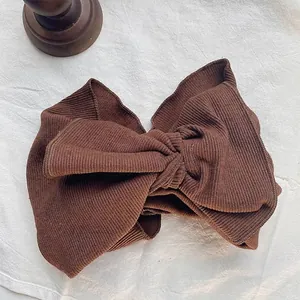 Close-up of a vintage brown ribbed cotton headband featuring an oversized bow design